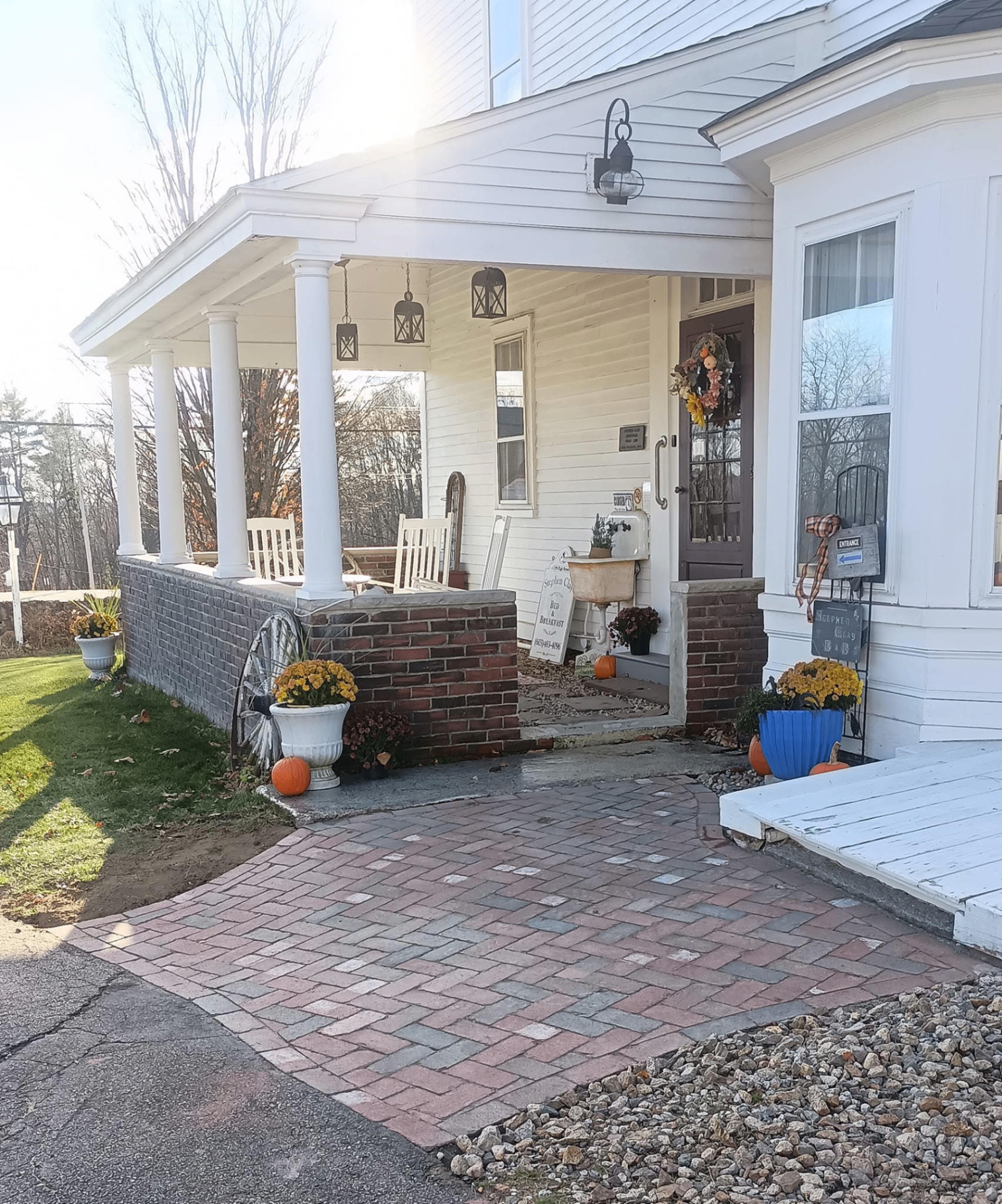 A herringbone brick walkway leading to a covered farmhouse porch